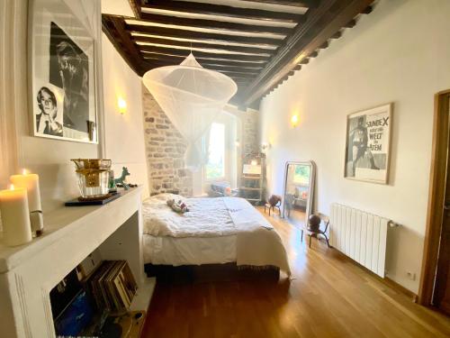 um quarto com uma cama e um lustre em La Suite Sainte Claire em Hyères
