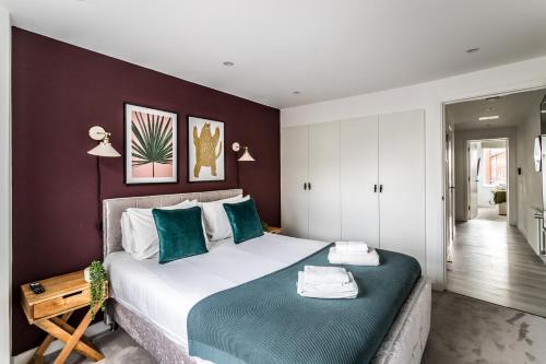 a bedroom with a large bed with green and white pillows at Borough Market 2-Bed Apartments in London