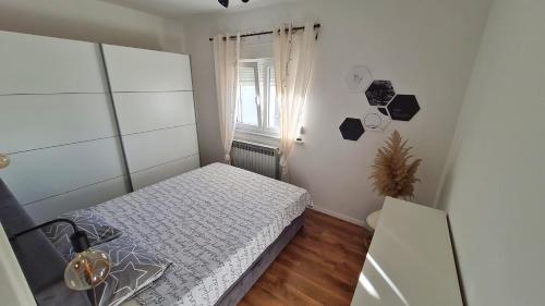 a small bedroom with a bed and a window at Apartman Noa in Jušići