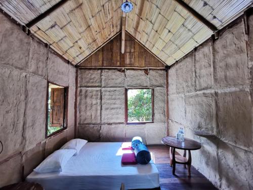 a room with a bed and a table in it at Harvest Moon Valley in Ban Pang Luang