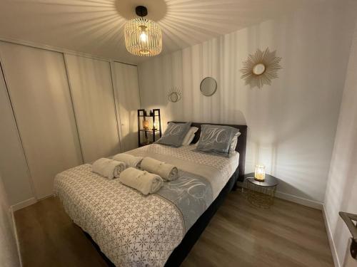 una camera con un letto con due cuscini sopra di Le colibri a Dinard