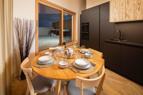 a kitchen with a wooden table with plates and glasses at Hillside Kubínska Hoľa - Apartmán Bird's eye view in Dolný Kubín