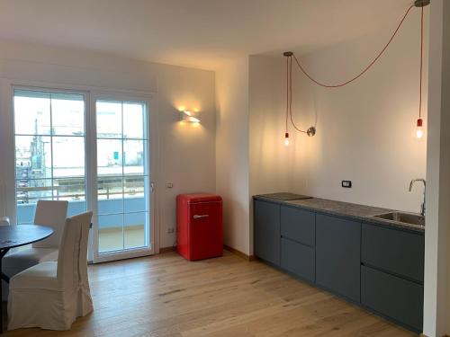 una cucina con un tavolo e un frigorifero rosso di Guest House Mela a Lecce