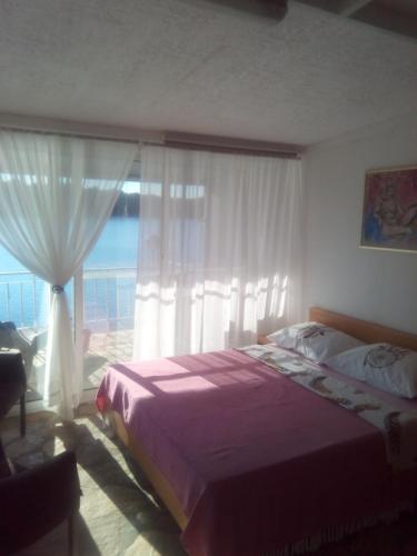 a bedroom with a bed and a large window at Apartment Ljilja in Blato