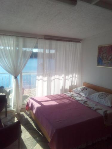 a bedroom with a bed and a large window at Apartment Ljilja in Blato