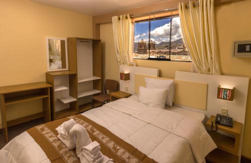 Un dormitorio con una cama grande y una ventana en Kaaro Hotel Puno, en Puno