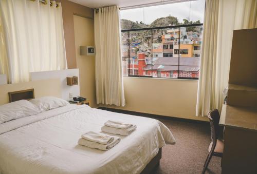 a hotel room with a bed with towels on it at Kaaro Hotel Puno in Puno