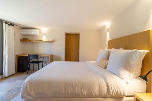 1 dormitorio con 1 cama blanca grande y escritorio en Mougins Collection - Ravissante Suite avec Bassin chauffé en saison, en Mougins