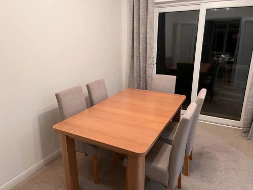 a wooden table and chairs in a room with a window at Beautiful 1 bed bungalow in Ryde