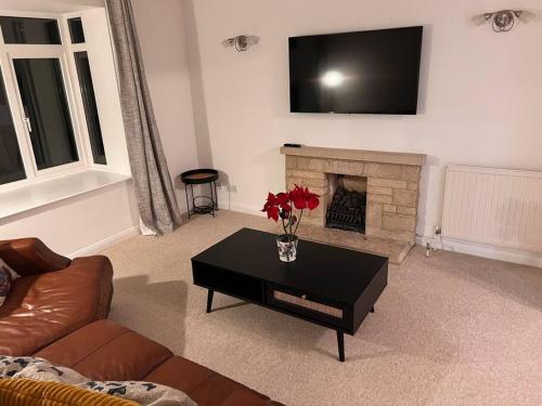 uma sala de estar com lareira e uma mesa de café preta em Beautiful 1 bed bungalow em Ryde