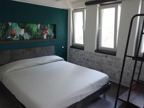 Ce lit se trouve dans un dortoir doté de murs verts et de fenêtres. dans l'établissement Casa Vacanze Malvarosa, à Spigno Saturnia