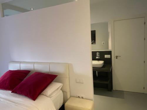 a bedroom with a bed with red pillows and a sink at Apartamento en Madrid Rio con Parking Gratuito in Madrid