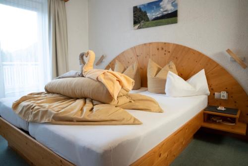 ゼーフェルト・イン・チロルにあるFerienhaus Ireneのベッド(木製のヘッドボード、枕付)