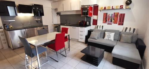 uma cozinha e uma sala de estar com um sofá e uma mesa em Maison de ville centre arles em Arles