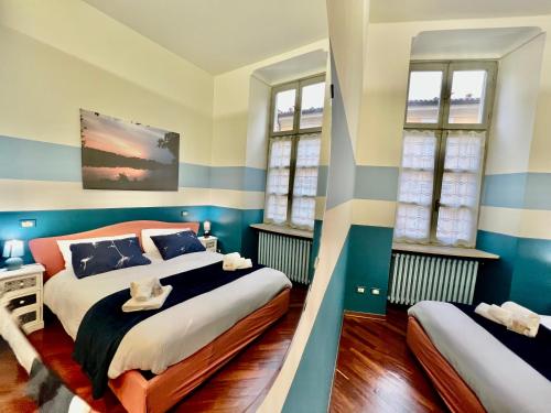 2 camas en una habitación con rayas azules y blancas en Novantasette passi dal Duomo, en Casale Monferrato