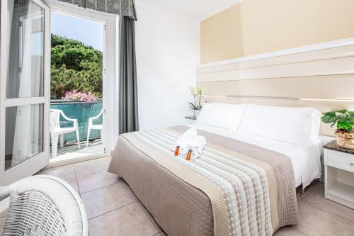 a hotel room with a bed and a balcony at Hotel Mediterraneo in Lignano Sabbiadoro