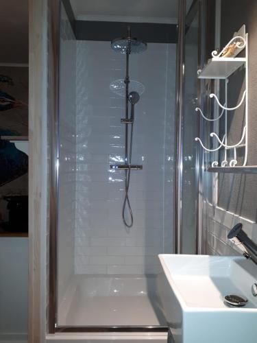 une douche dans une salle de bain avec un lavabo et une baignoire dans l'établissement La Perle Secrète, à Theneuille