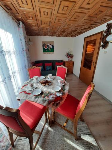 comedor con mesa y sillas rojas en Mały Domek, en Zwardoń