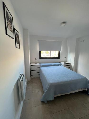 Un dormitorio con una cama azul y una ventana en Departamento B° Guemes con cochera en Córdoba