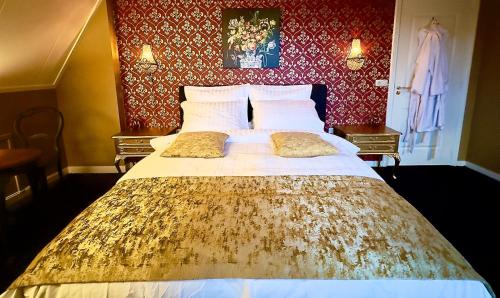 a large bed in a bedroom with red wallpaper at Villa Giethoorn Steenwyck in Steenwijk