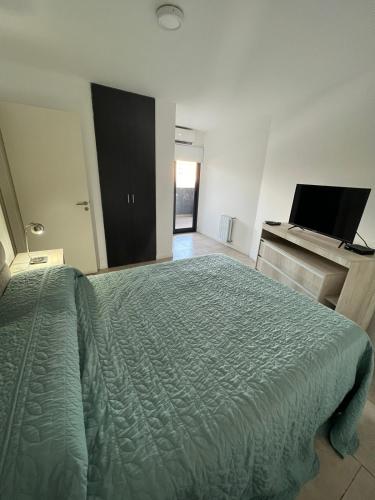 1 dormitorio con cama verde y escritorio en Departamento B° Guemes con cochera en Córdoba
