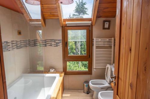 baño con bañera grande y aseo en Casa Santa Clara en San Carlos de Bariloche