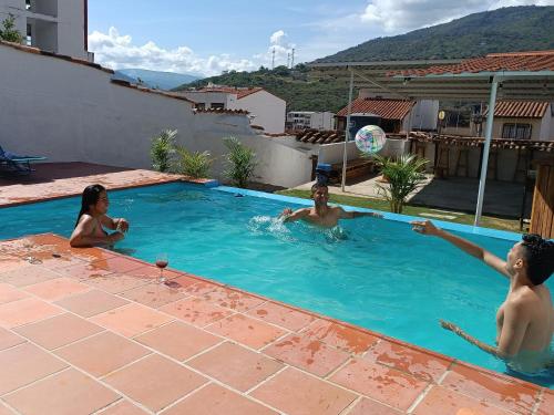 three people playing with a ball in a swimming pool at The Best Adventure Hostel in San Gil