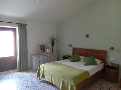 CasoliにあるLe Farfalle Abruzzoのベッドルーム(緑の枕とテレビ付)