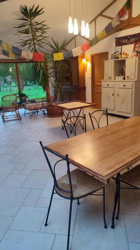 a large room with tables and chairs and a palm tree at Les Gîtes KARMA in Andres