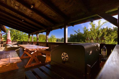 a patio with a grill and a table on a deck at Willa SPAcja in Wężówka