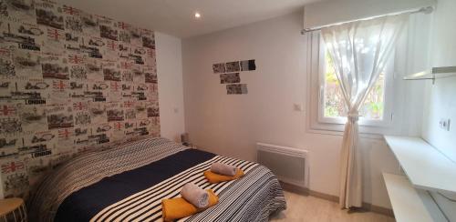 a bedroom with a bed with two pillows and a window at Le Silène in Sainte-Maxime