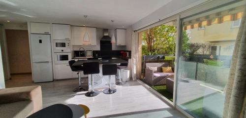 une cuisine et un salon avec une table et des chaises dans l'établissement Le Silène, à Sainte-Maxime