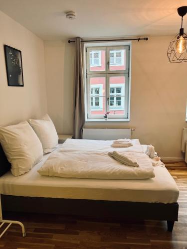 a bed in a room with a window at Zentrales charmantes Apartment im Altstadtkern in Bayreuth