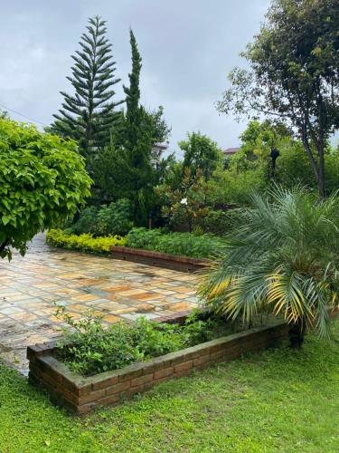 a garden with a brick walkway in a yard at Avocado Accommodations in Khadkagaon