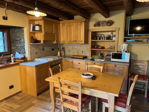 聖雷米恩博塞斯的住宿－Grandze du Pleiney，厨房配有木桌和桌椅