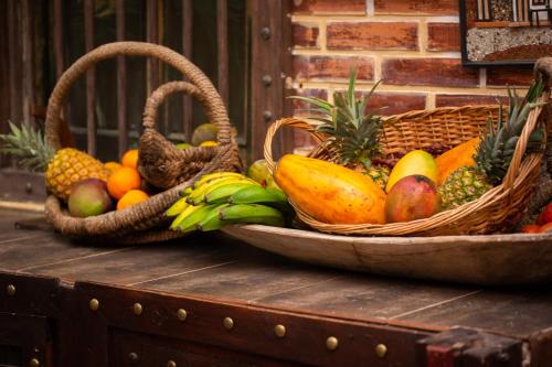 two baskets of fruit on top of a wooden chest at Entre Palmas Casa Hotel in Santa Fe de Antioquia