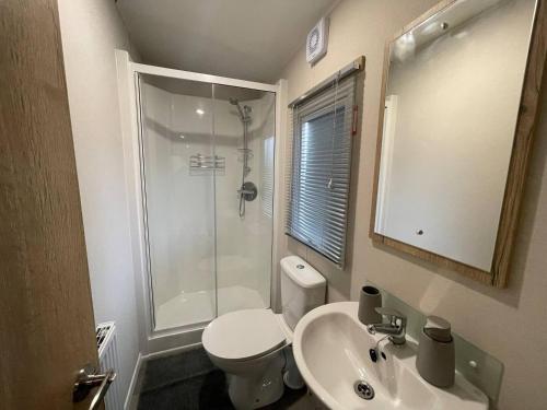 ein Bad mit einer Dusche, einem WC und einem Waschbecken in der Unterkunft Sleepy Hollow Holiday Home in Knaresborough