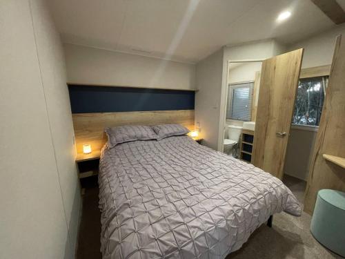 a bedroom with a bed and a desk with two lamps at Sleepy Hollow Holiday Home in Knaresborough