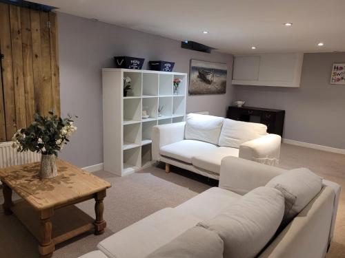 a living room with two white couches and a table at Beach Walk Sandgate in Sandgate