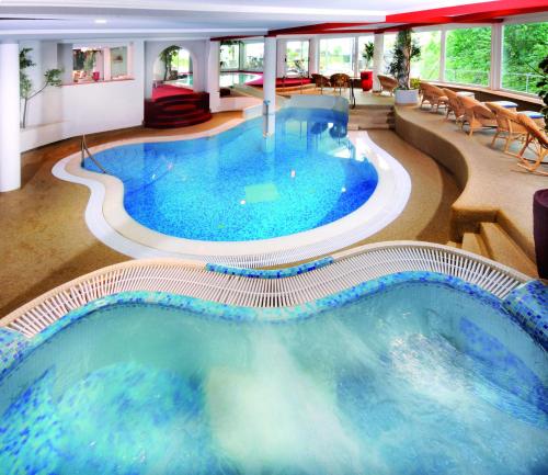 a large pool with blue water in a hotel room at Der Verdinser Hof in Schenna