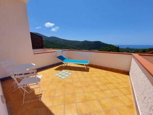a balcony with a blue bench and chairs on it at Itaca Rooms Palinuro in Palinuro