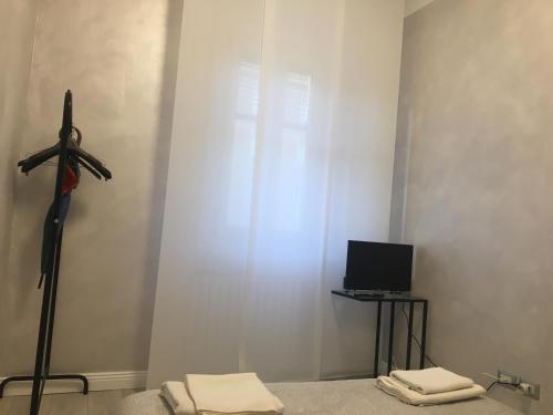 Zimmer mit einem Kreuz an der Wand und einem TV in der Unterkunft Studio Monte Ceneri in Mailand