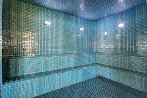 a blue tiled bathroom with blue tiles on the wall at Condomínio VG sun Cumbuco in Cumbuco