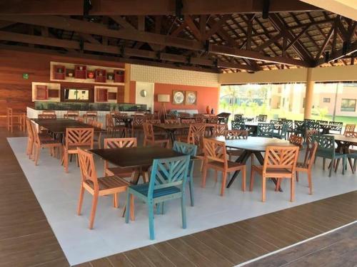 a restaurant with tables and chairs in a room at Condomínio VG sun Cumbuco in Cumbuco