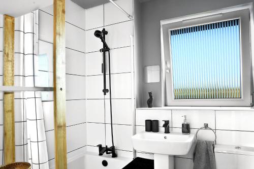 a white bathroom with a sink and a shower at A cosy house near the city centre in Glasgow