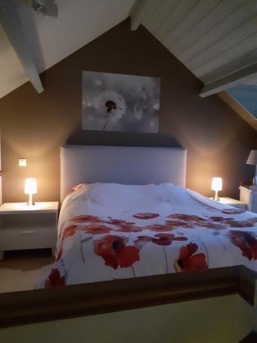 Un dormitorio con una cama con flores rojas. en Au Ptit Coquelicot, en Houyet