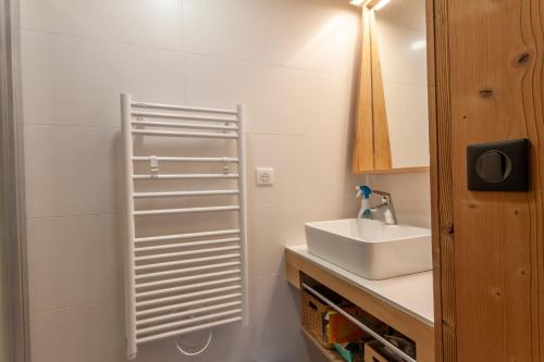 une salle de bain blanche avec un lavabo et un miroir dans l'établissement Les Amarelles, à Morzine