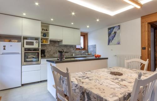 une cuisine avec une table et un réfrigérateur blanc dans l'établissement Les Amarelles, à Morzine