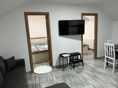 a living room with a couch and a tv on a wall at Aster Apartments in Belgrade