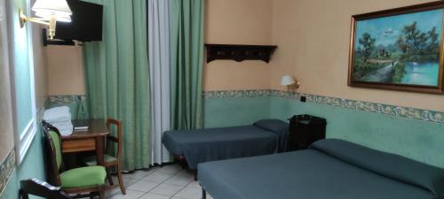 ローマにあるHotel Montreal Unoのベッド2台、テーブル、デスクが備わる客室です。